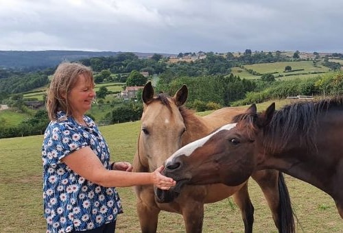 Emma feeding two horses